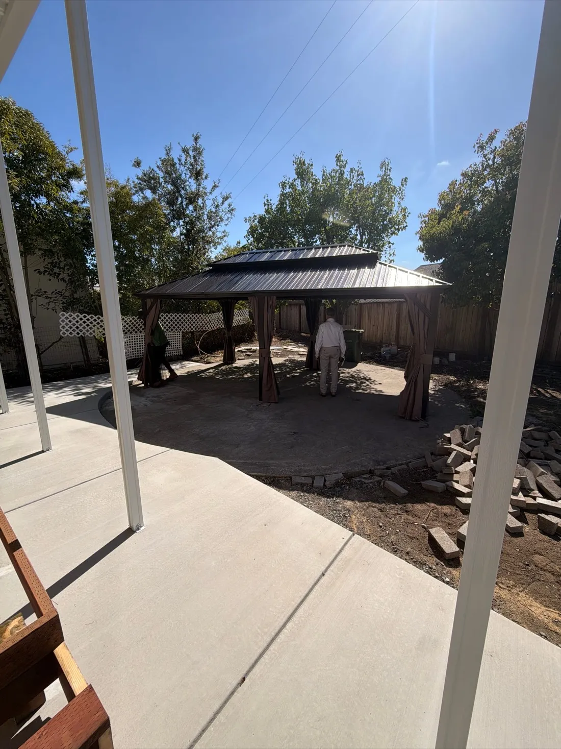 Completed hardtop gazebo with double-tier metal roof in a fenced backyard — Zomg The Handyman