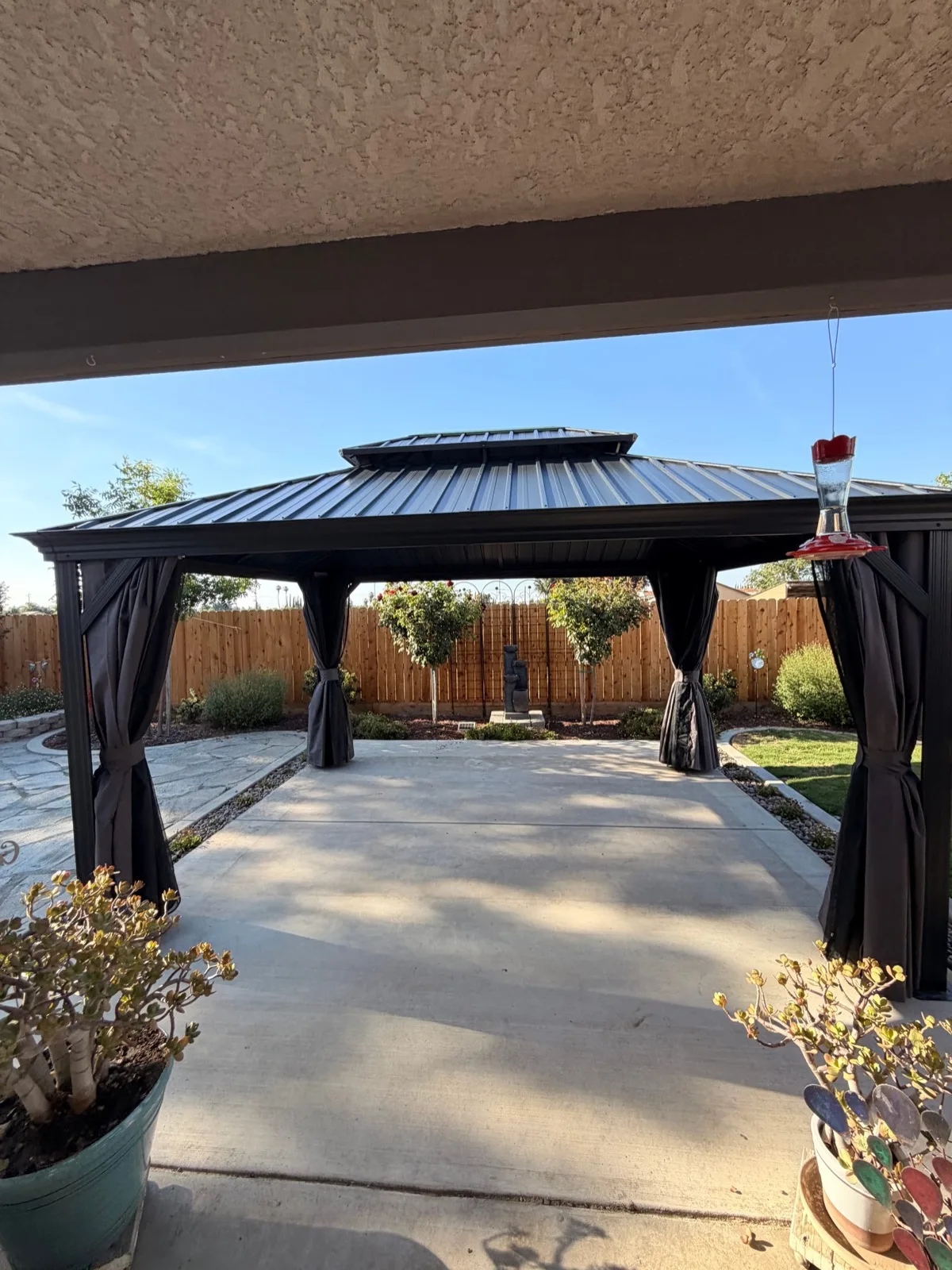 Custom metal-frame gazebo with peaked roof and curtain panels, fully assembled