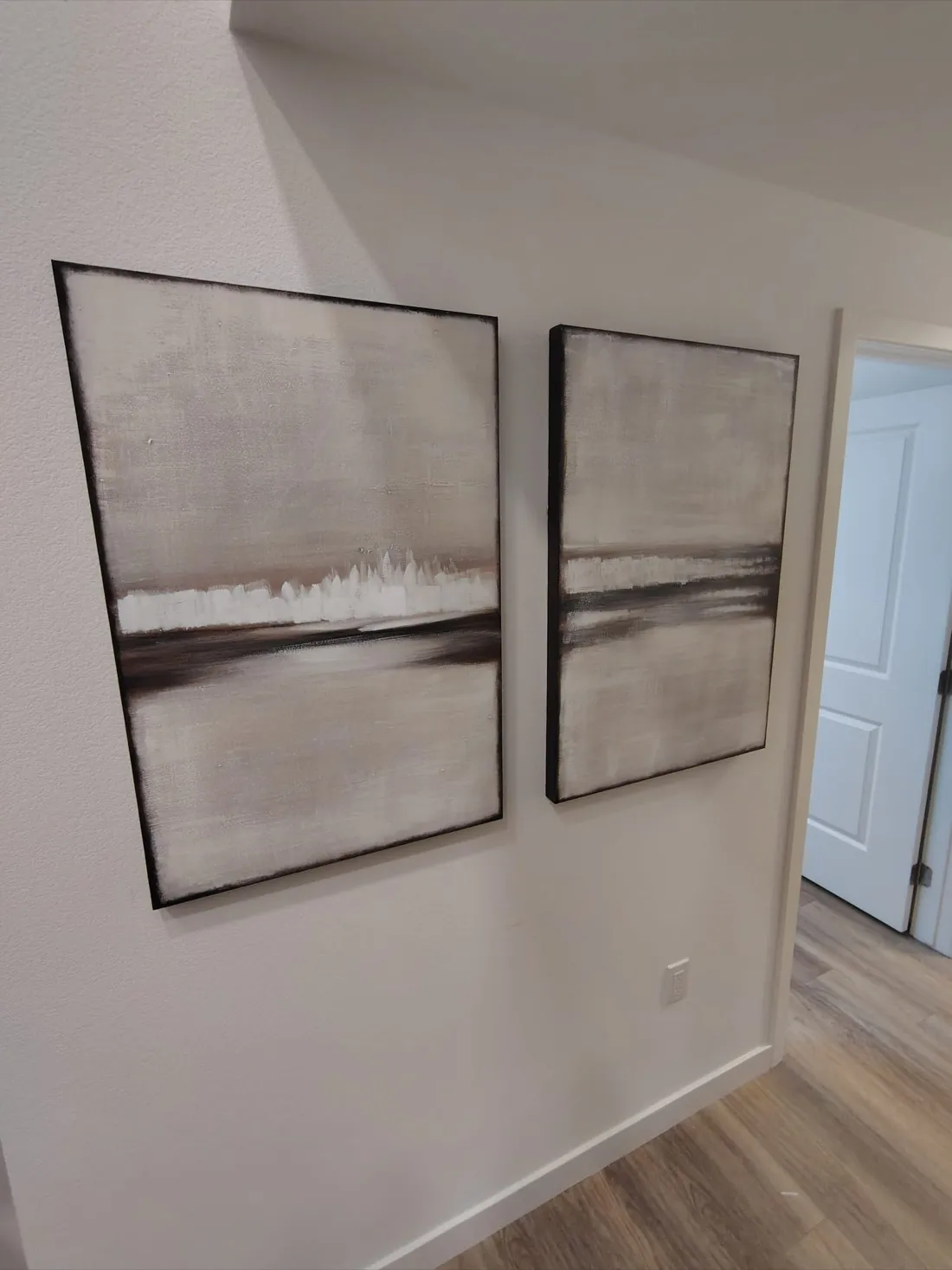 Two framed abstract landscape artworks professionally hung on hallway wall — Zomg The Handyman