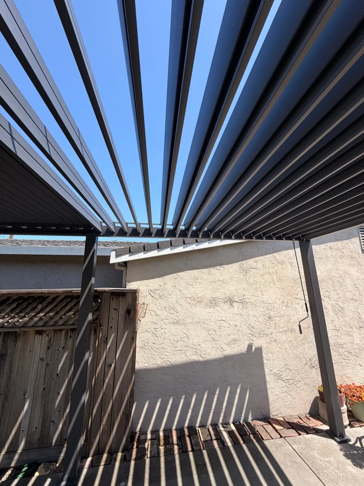 Modern pergola with automated louvered aluminum roof installed over a patio