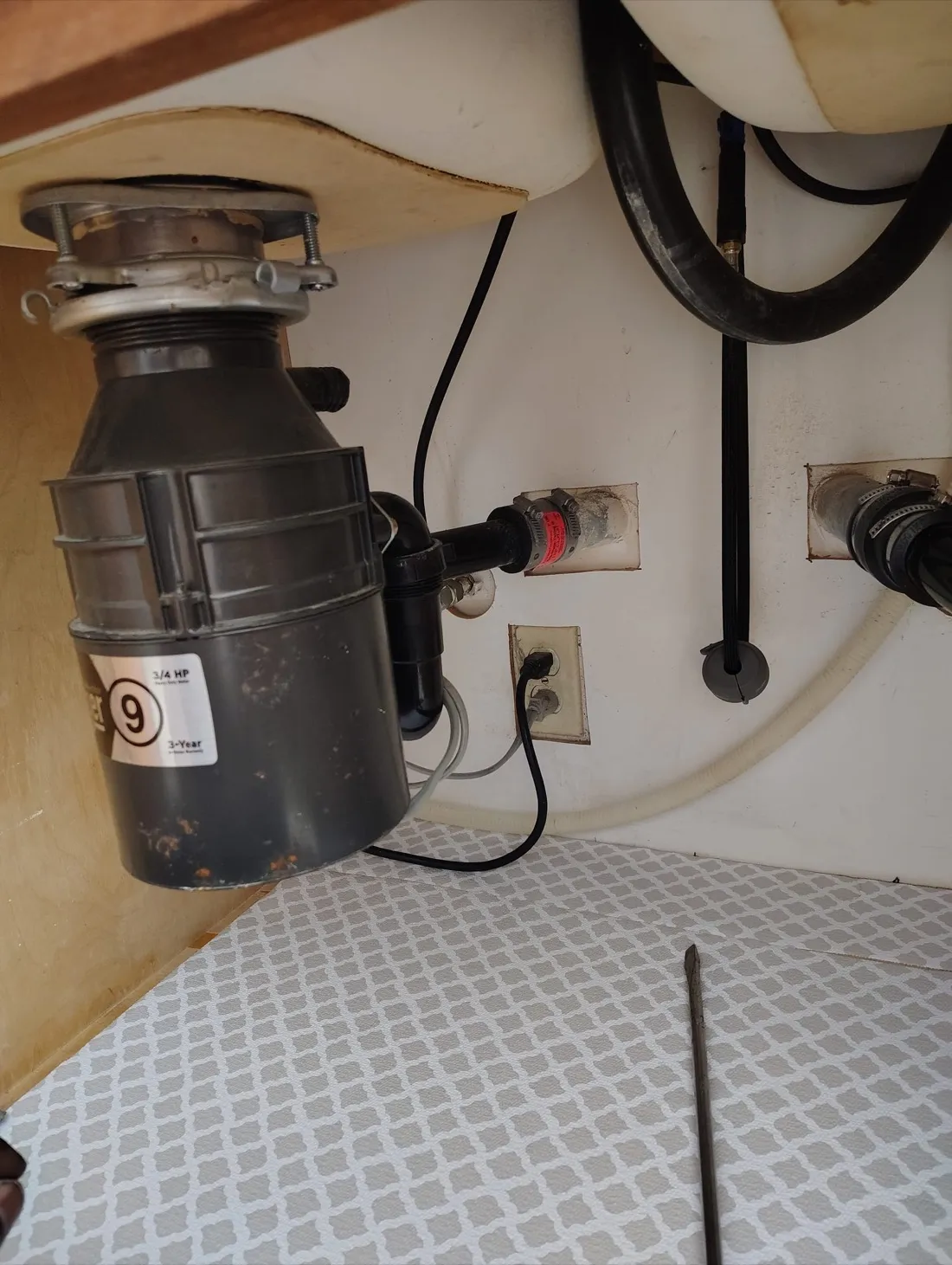 Garbage disposal unit installed under kitchen sink with discharge piping — Zomg The Handyman