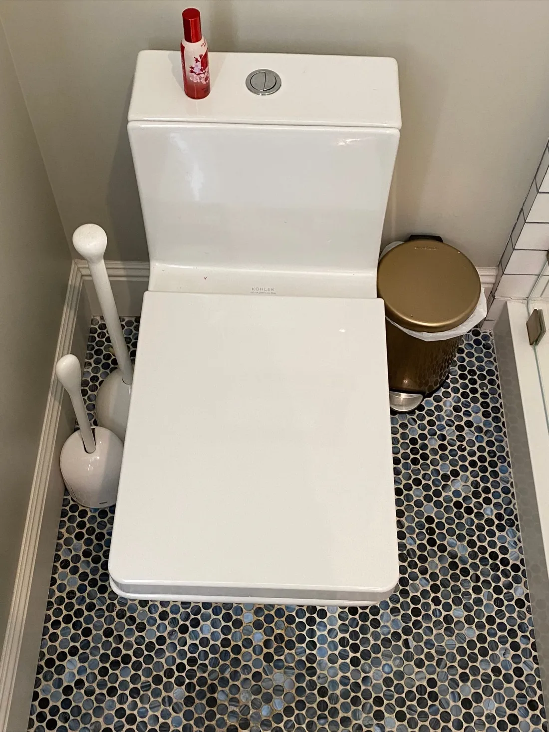 Newly installed white toilet with elongated bowl in a bathroom with black and white hexagonal tile flooring. — Zomg The Handyman