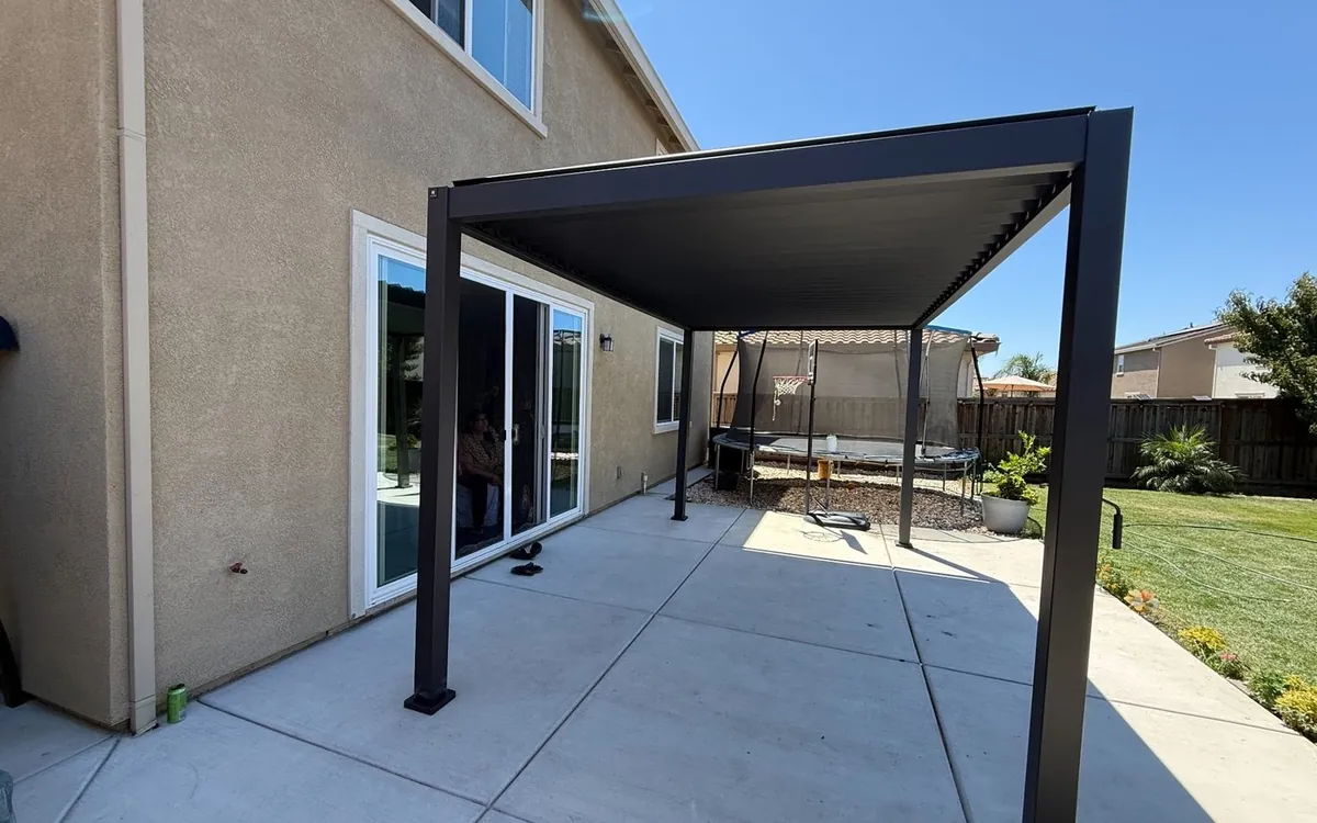 Black louvered pergola attached to the house, a Zomg assembly