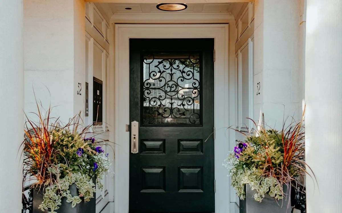 Black front door with two planters