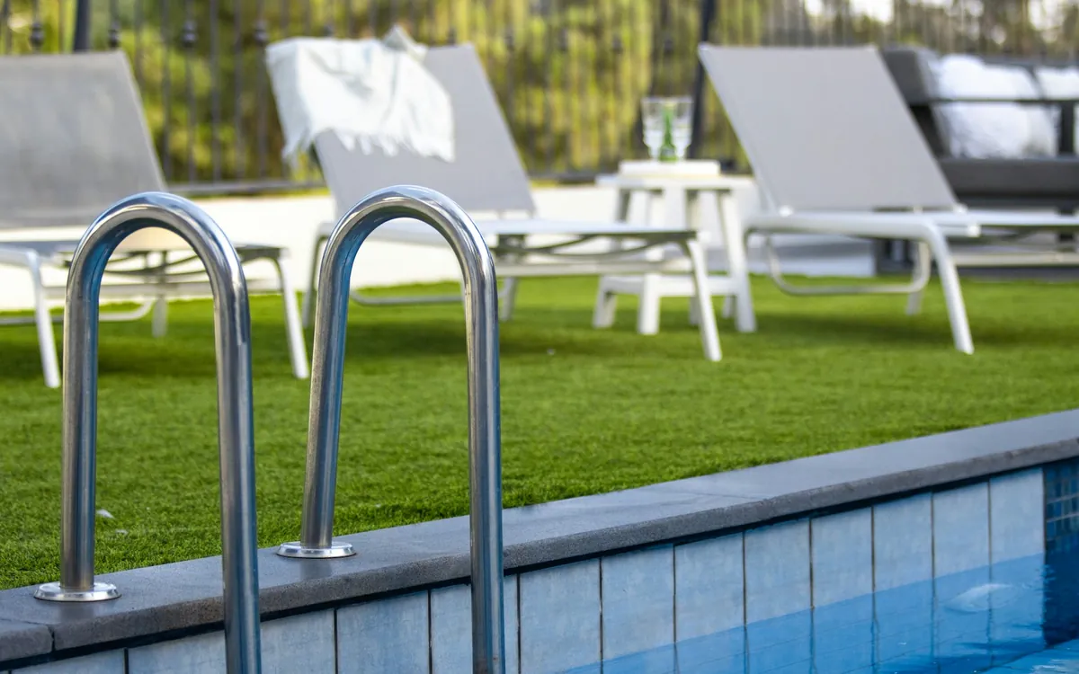 Swimming pool ladder and lounge chairs