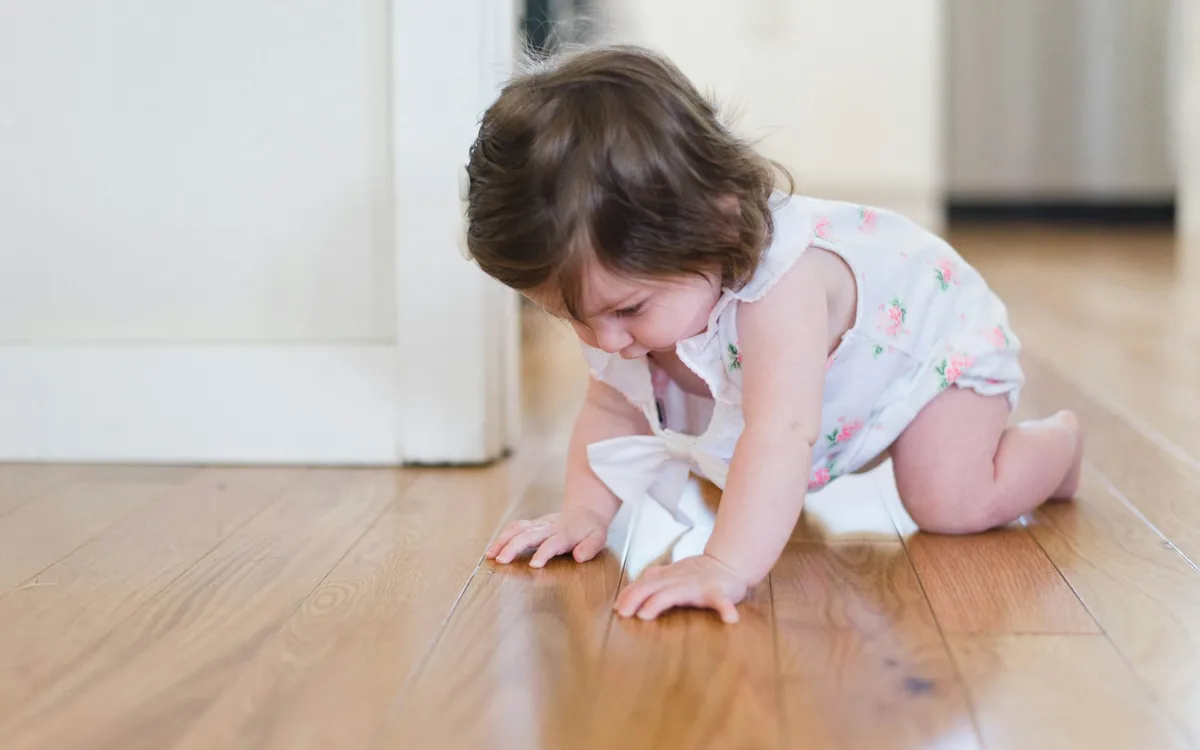 Toddler crawling on a wood floor