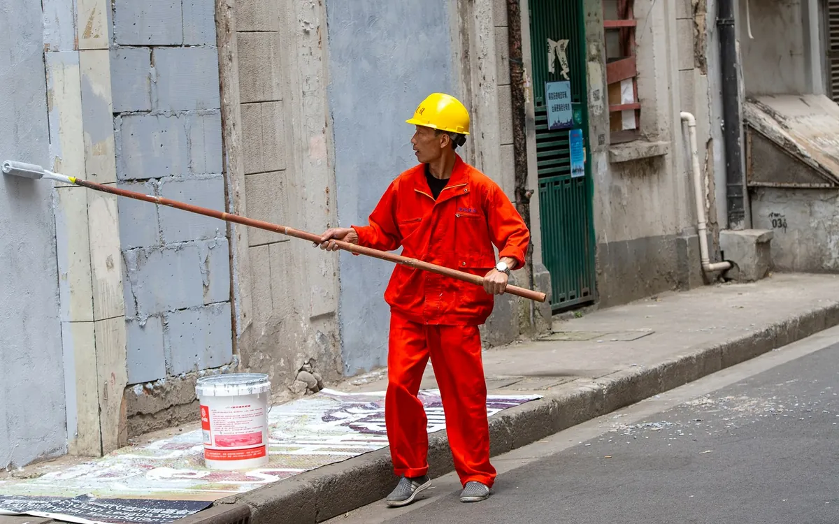 Painter spraying a building exterior