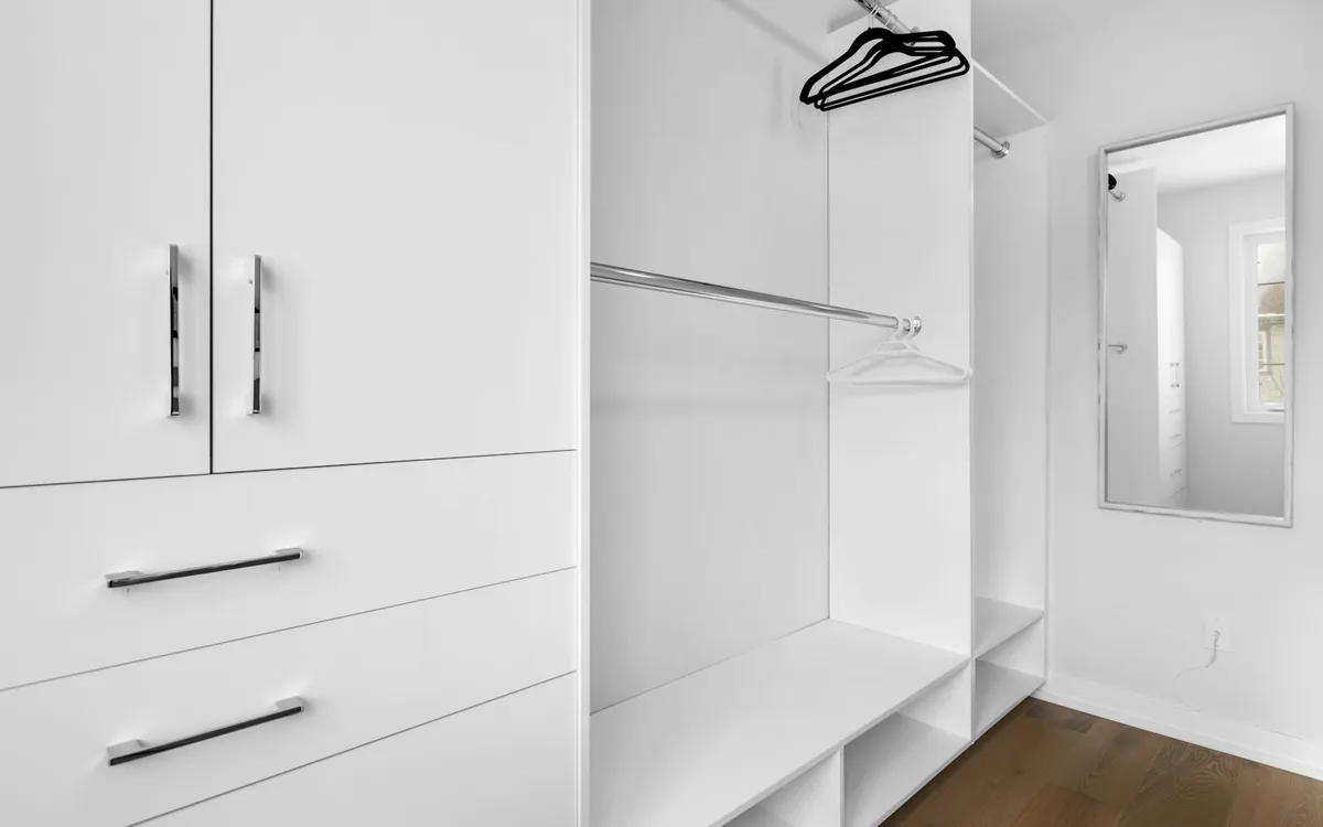 Walk in closet with white cabinets